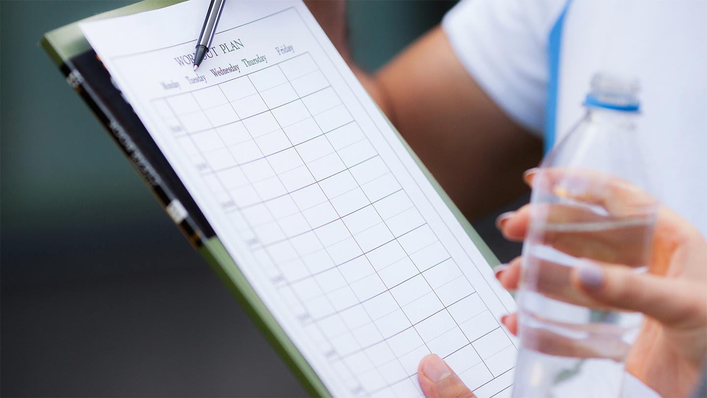 person holding clipboard of fitness goals