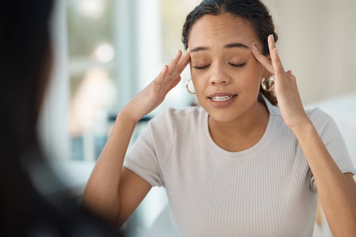 women holding head with headache or migraine