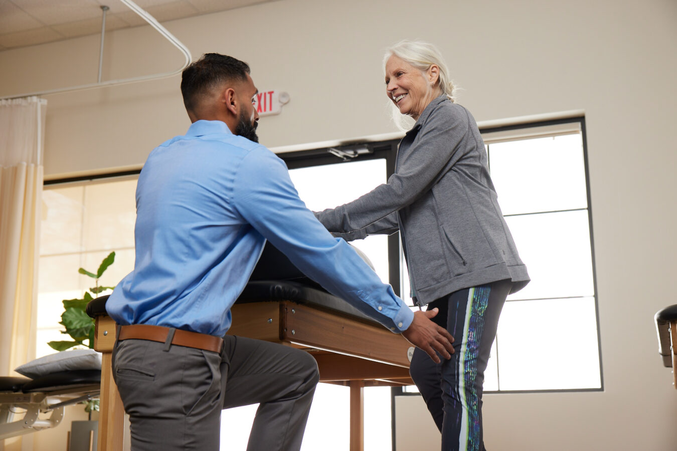 smiling senior woman working with doctor for Parkinson's Disease