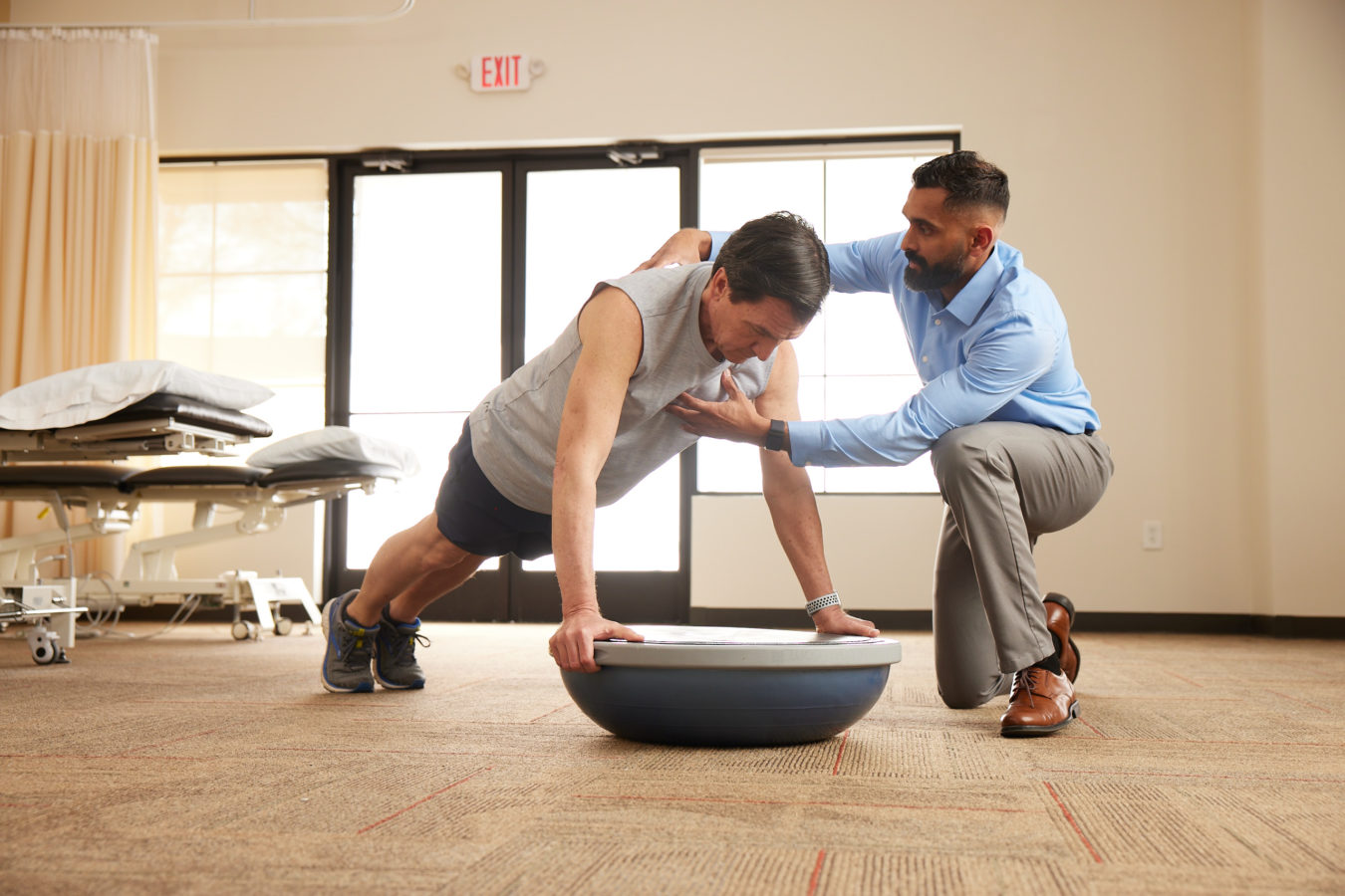 physical therapist helping patient strengthen core muscles