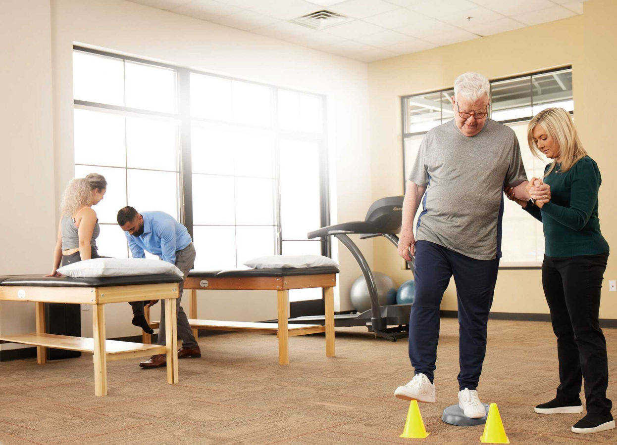 two physical therapists helping their patients during an appointment