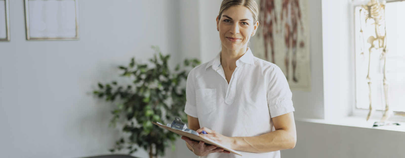 female physical therapist with blonde hair and white blouse on