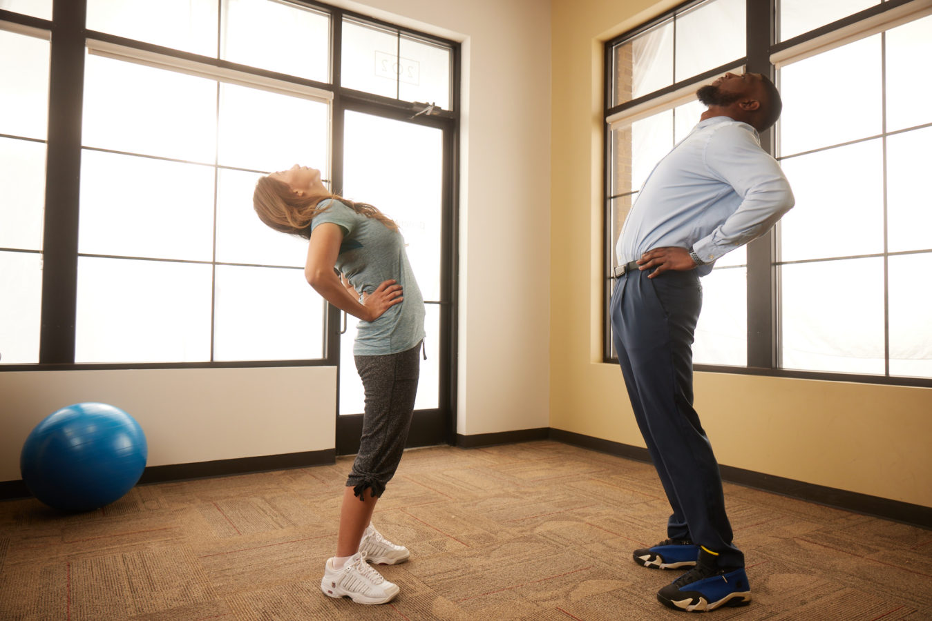 man and woman with spinal stenosis stretching their backs