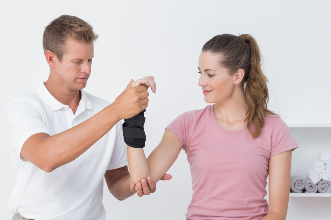 physical therapist examining a womans wrist