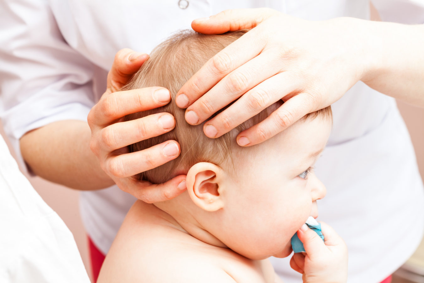 Infant receiving osteopathic treatment of her head