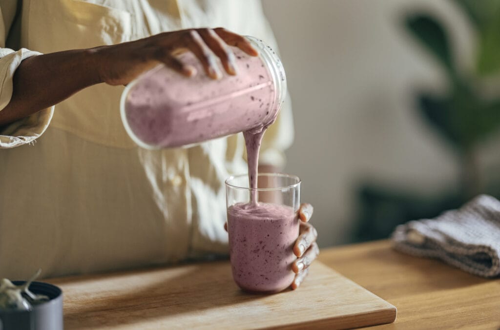 Woman pouring a healthy drink in a glass